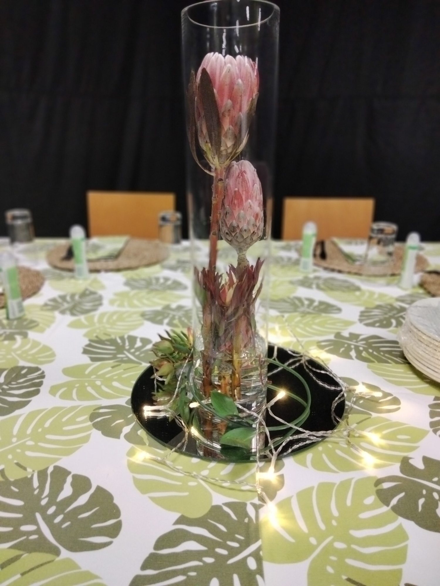 Floral centerpiece in a glass vase with greenery