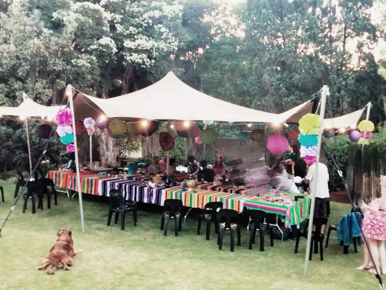 Outdoor event setup with colorful tables and black chairs