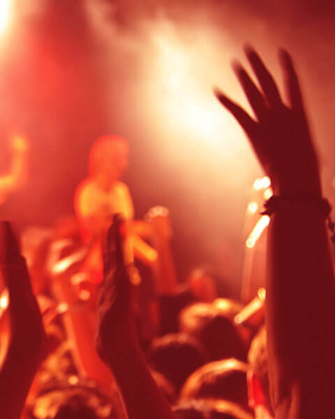 Audience hands raised in a lively event setting