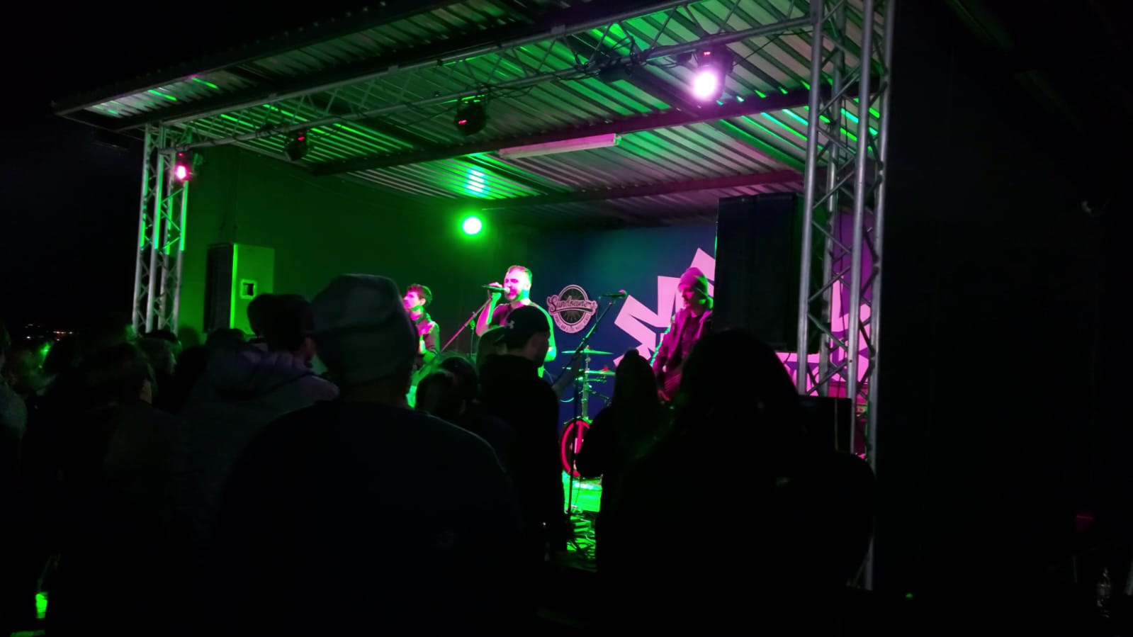 A band performing on stage with colorful lighting