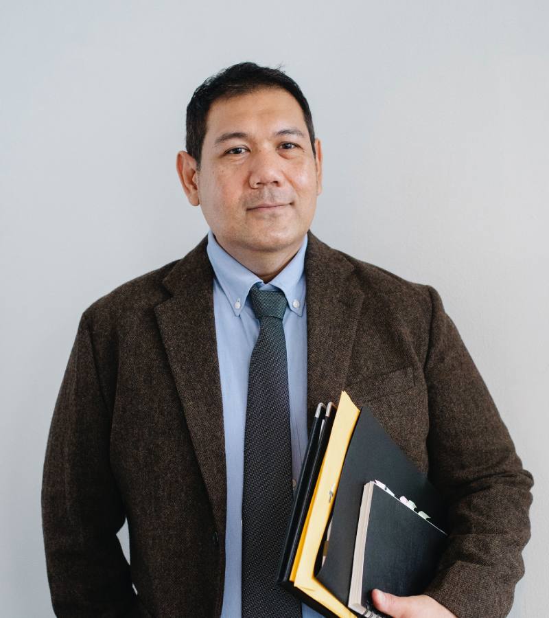 Man in a suit holding folders, representing sound consultation services.