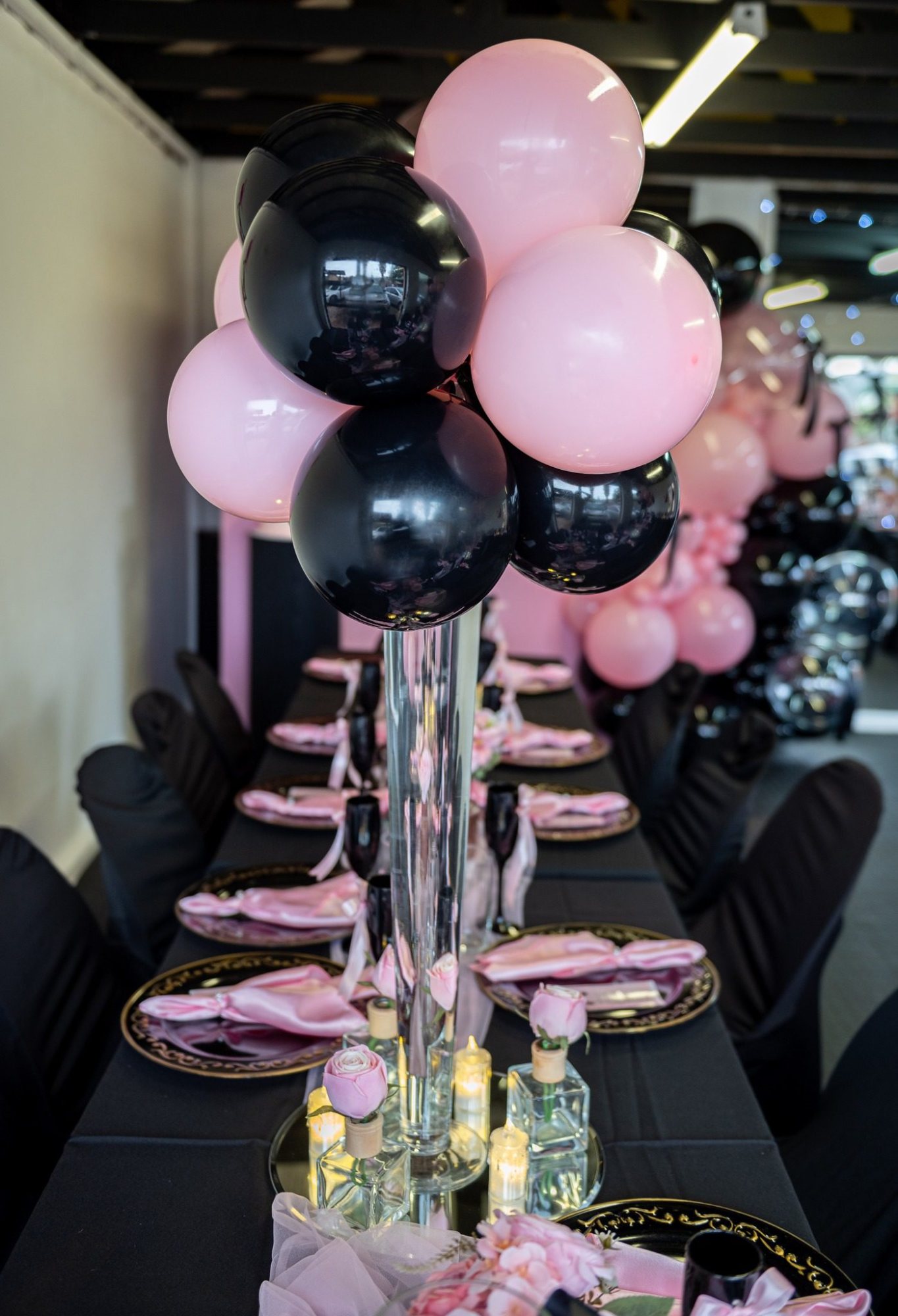 Table centerpiece with pink and black balloons in glass vase