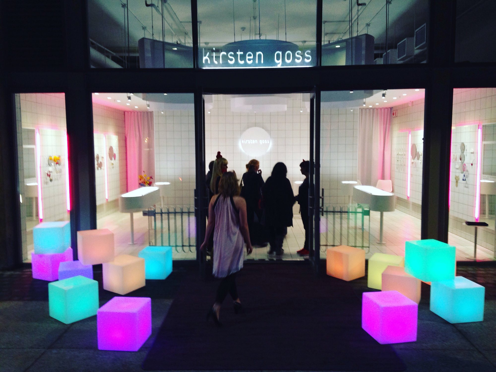 Illuminated seating cubes at an event entrance.