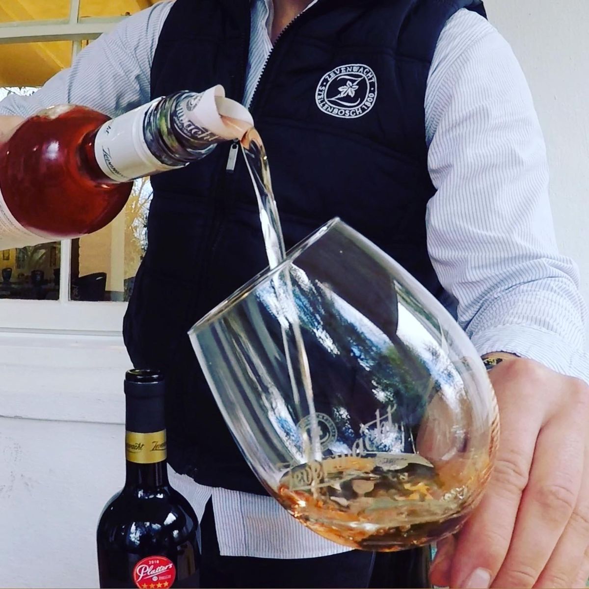Pouring rosé wine into a glass with attention to detail.