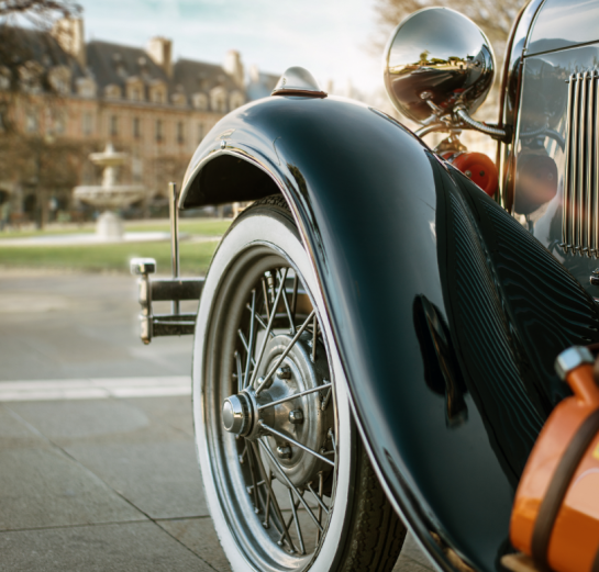 Close-up of a vintage car in a scenic outdoor setting