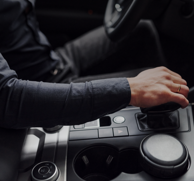 Close-up of a hand on the gear shift in a classic car