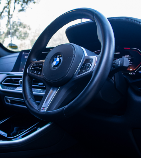 Interior view of a BMW classic car with steering wheel and dashboard