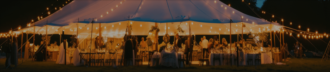 Marquee tent illuminated with string lights and tables set for an event