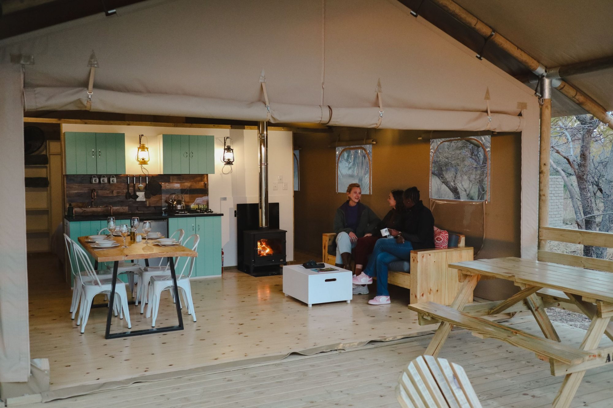 Interior view of a glamping tent showing seating and kitchen area