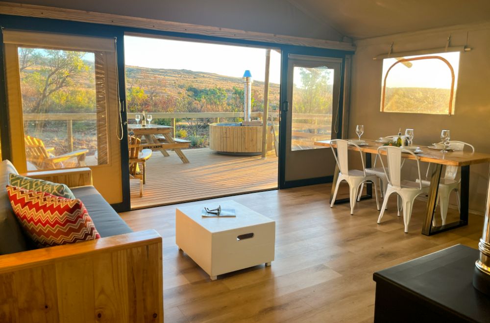 Interior view of a boutique glamping tent with seating and dining area