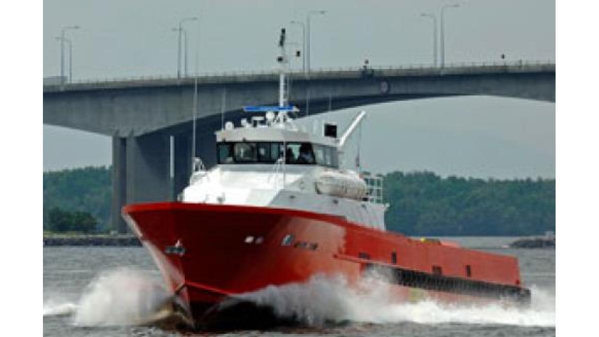 A red and white boat navigating on a river.