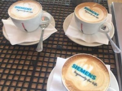 Three coffee cups with branded foam designs