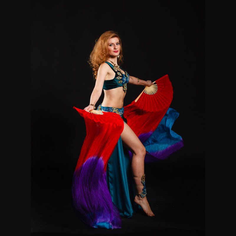 Belly dancer in red and blue costume holding fans