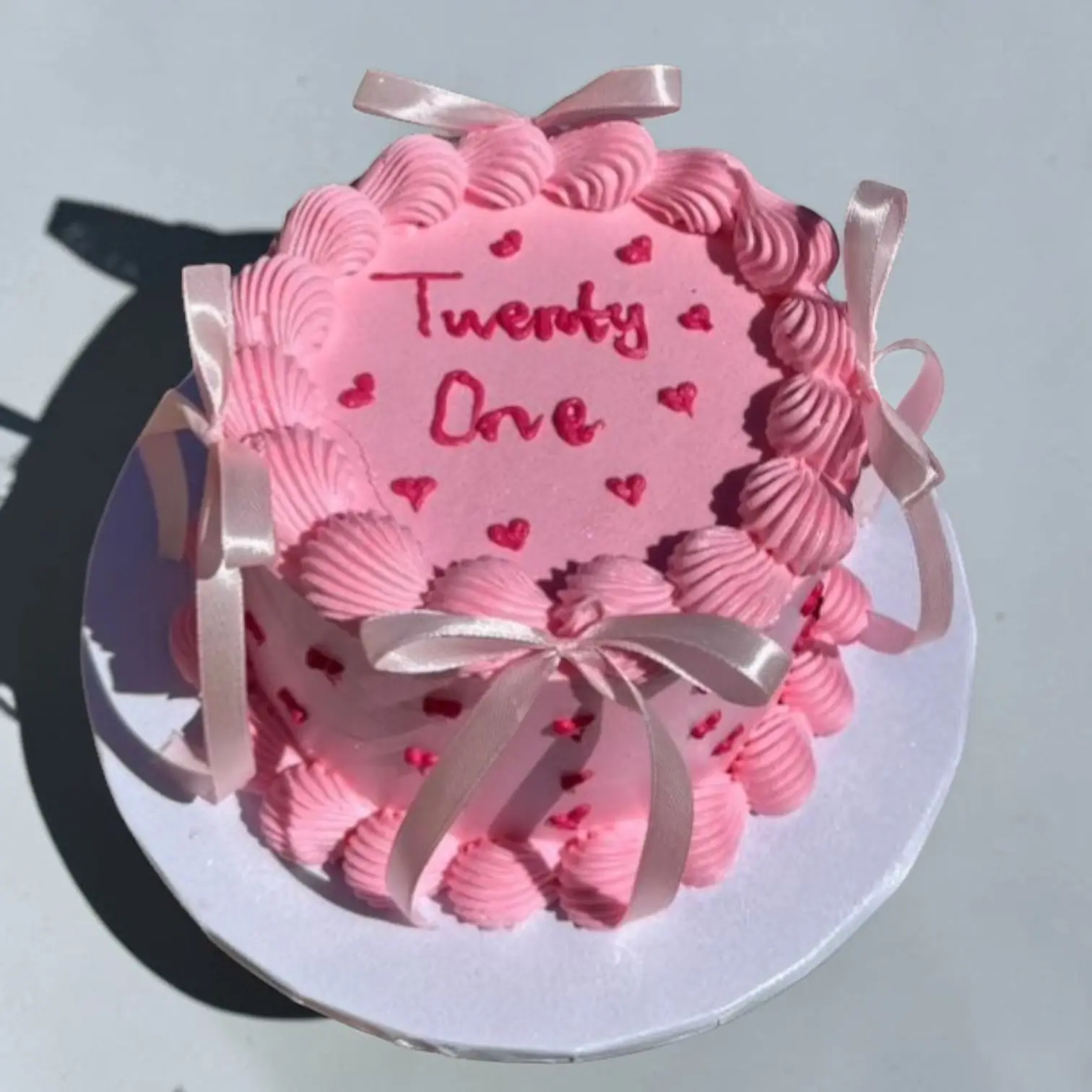Small pink cake with 'Twenty One' and hearts decoration