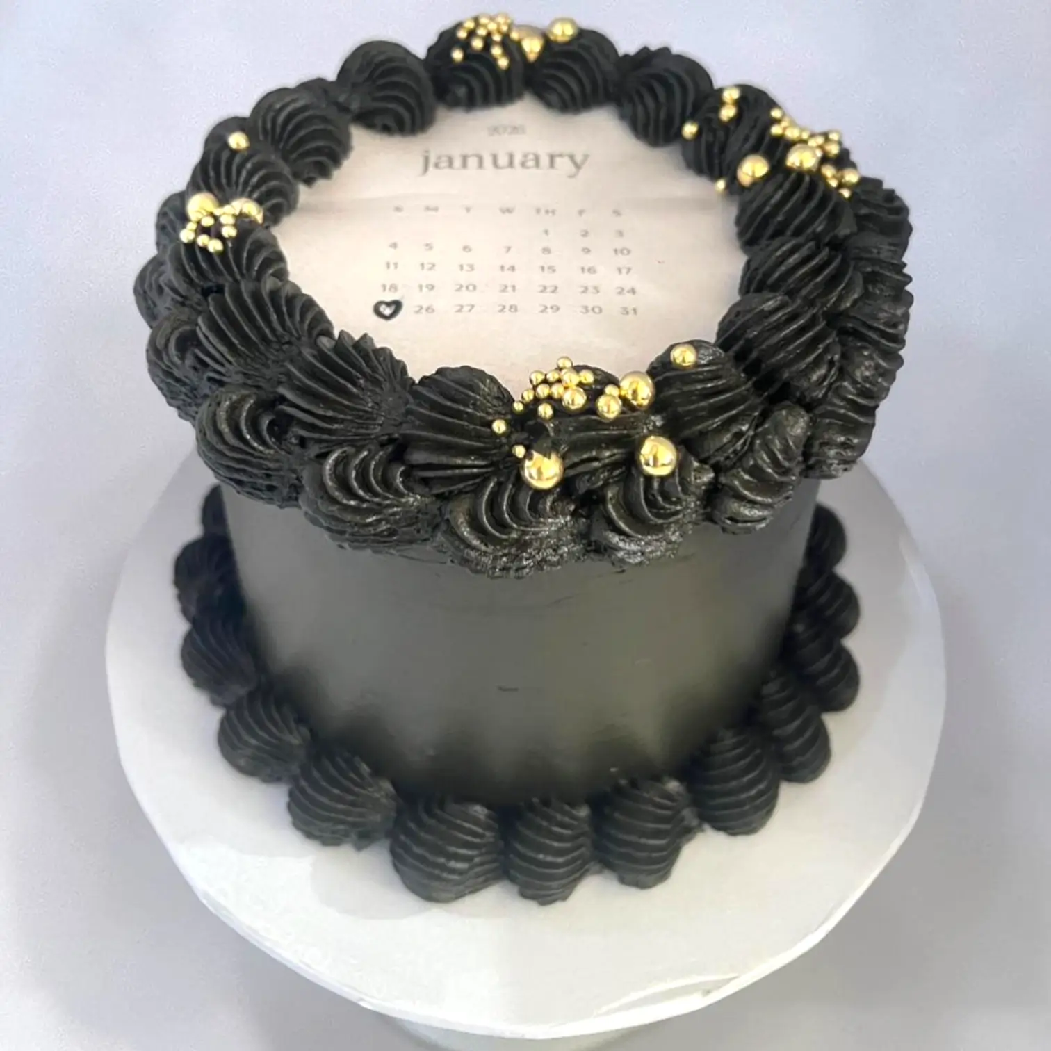 Black and gold cake with January calendar on top
