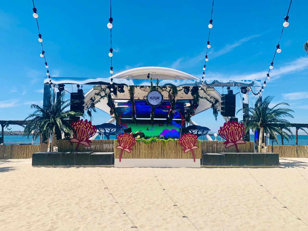 Beachfront stage with lighting and digital screens
