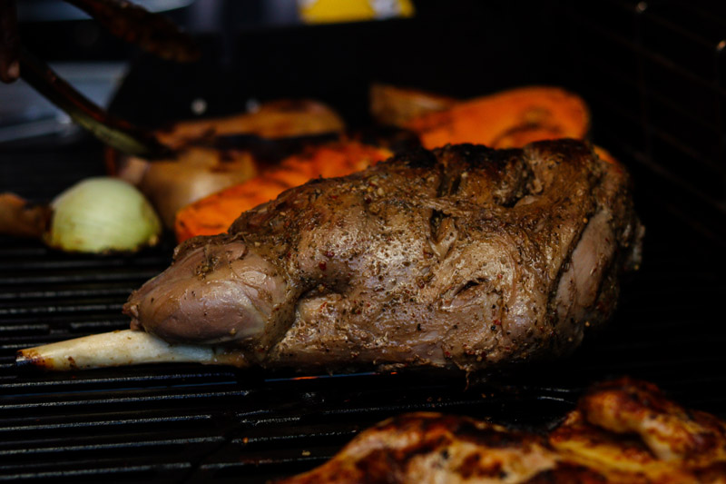 Close-up of a marinated lamb roast on a grill.