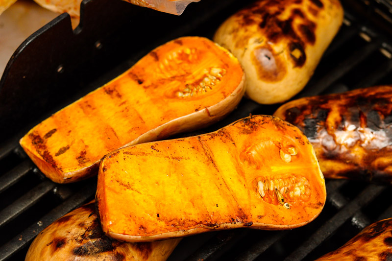 Grilled butternut squash slices on a grill