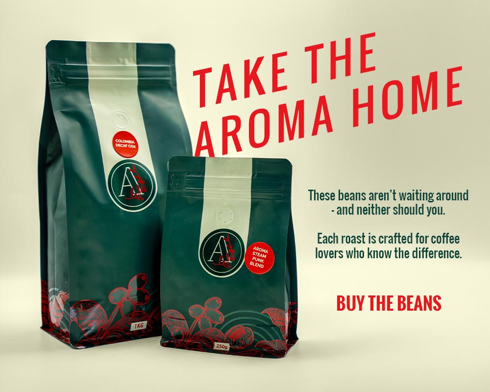 Two bags of Aroma coffee beans on a neutral background.