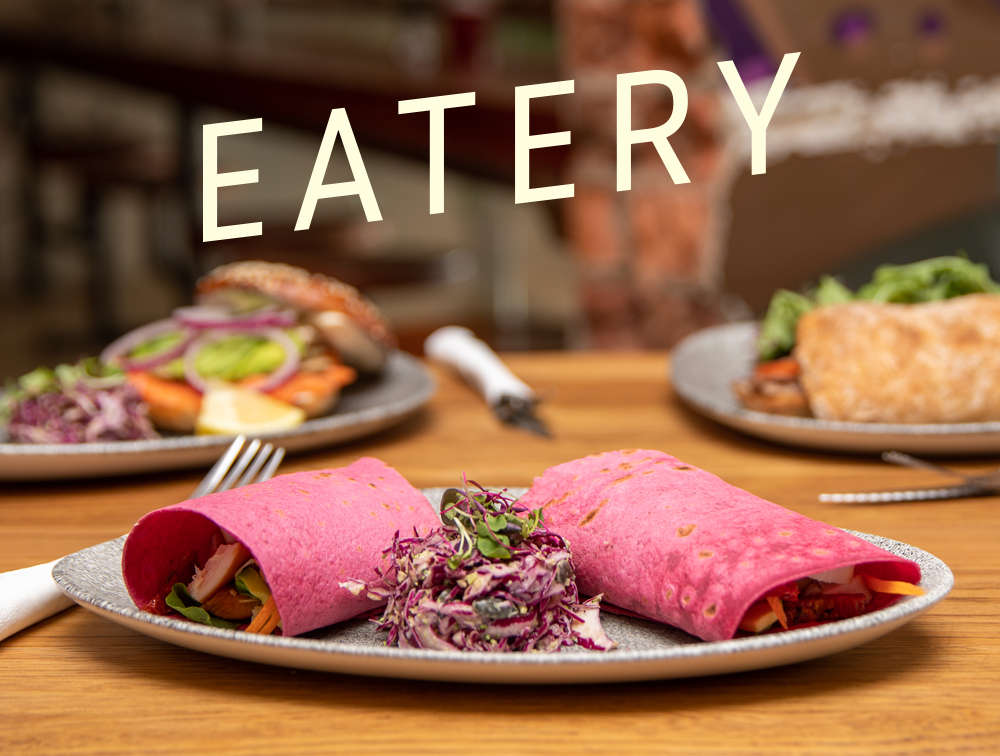 Two pink wraps on a grey plate with coleslaw