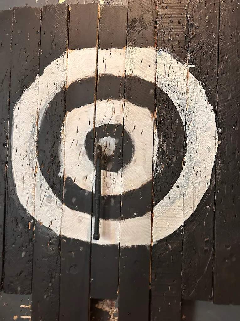 Close-up of an axe throwing target with an axe embedded.