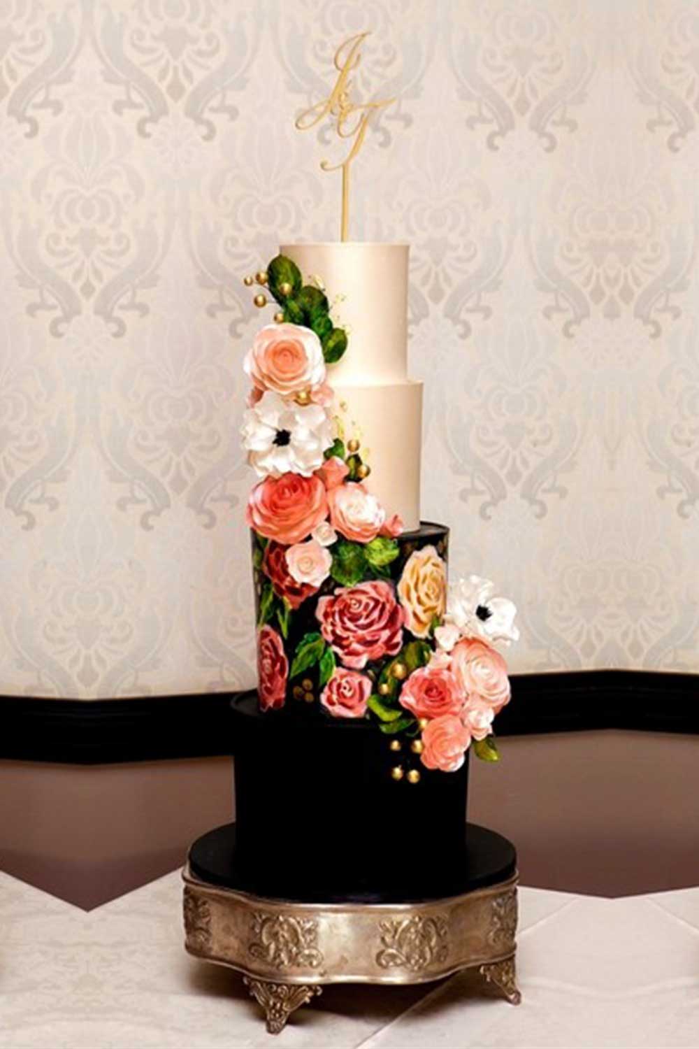 Three-tiered wedding cake with sugar flowers and elegant topper