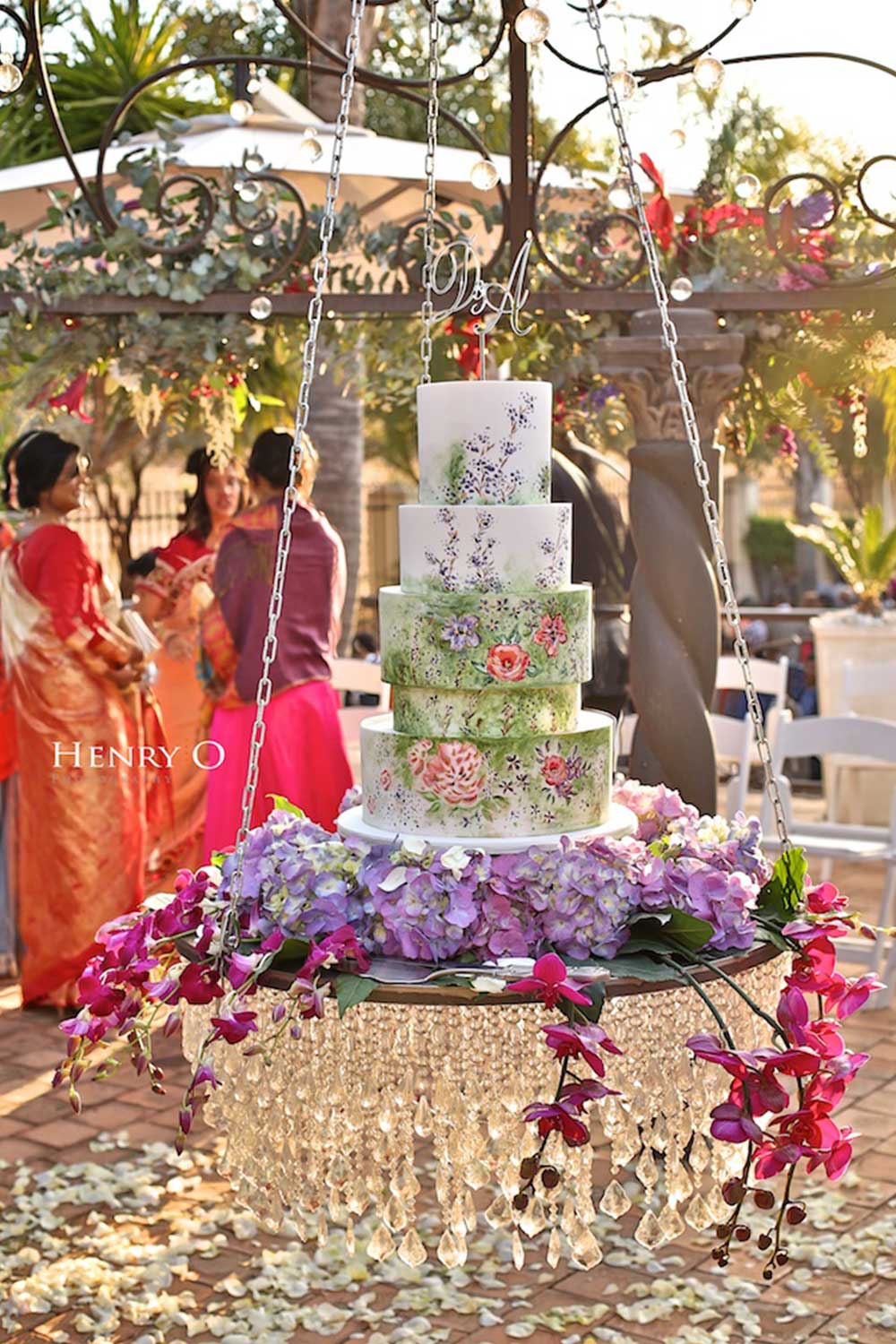 Floral wedding cake hanging with purple orchids and crystals