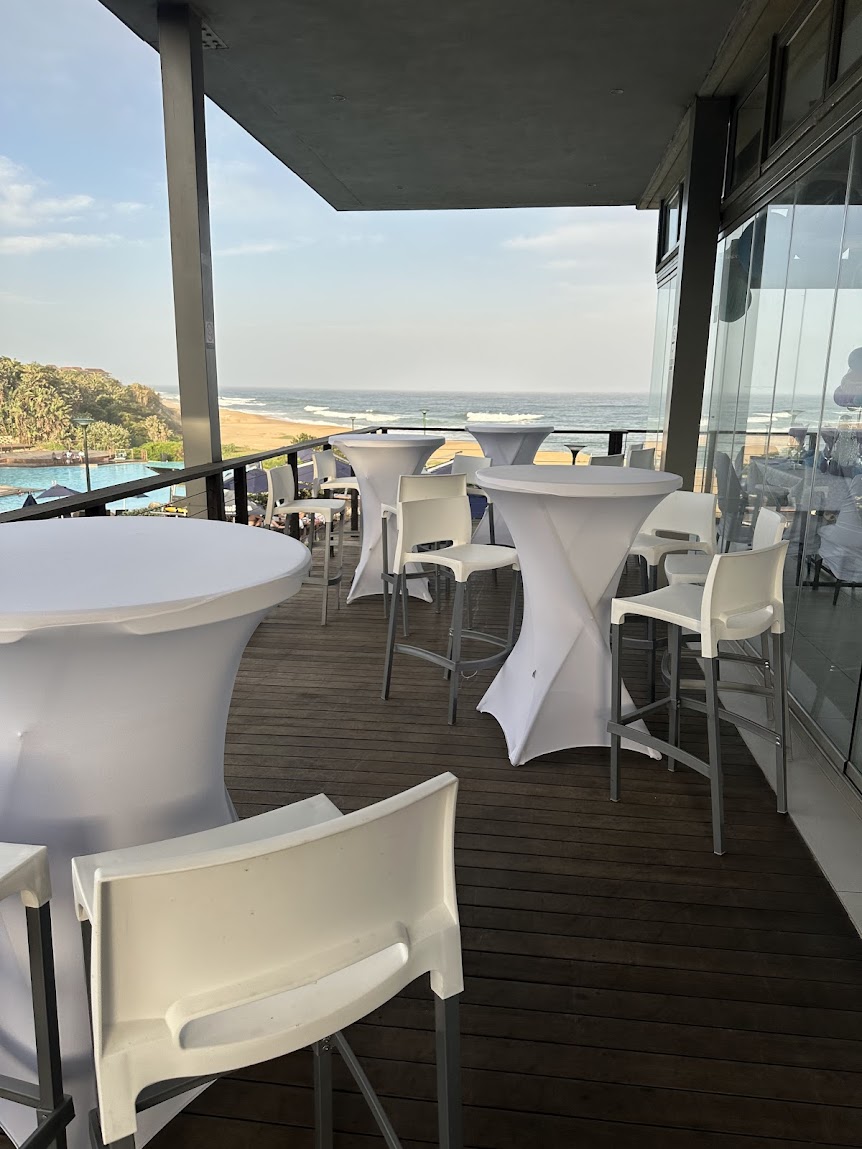 Outdoor event with white cocktail tables and ocean view