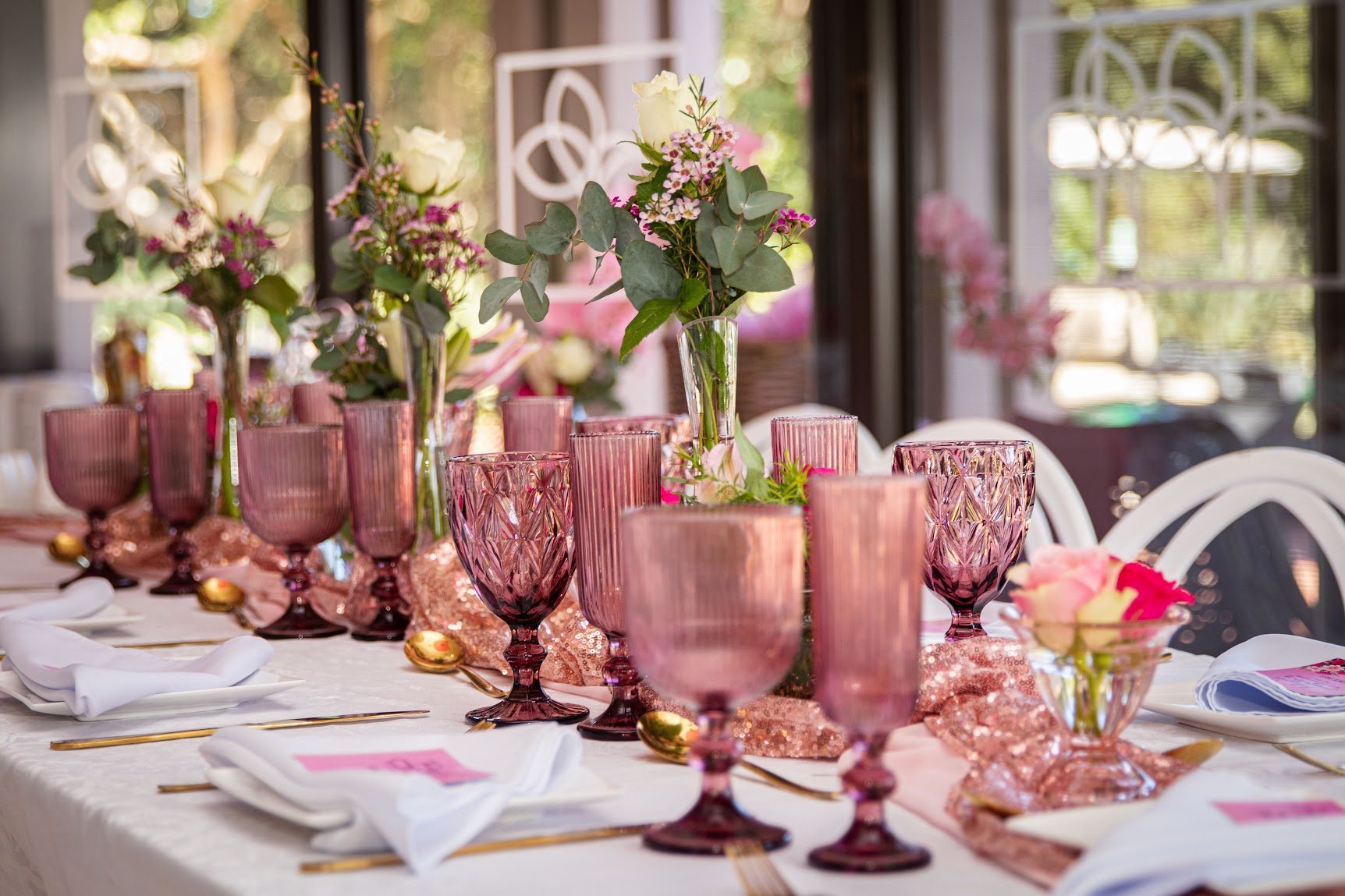 Elegantly arranged table with pink glassware and flowers