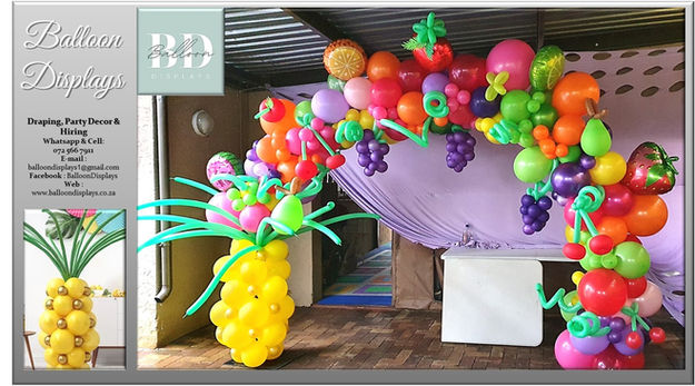 Colorful fruit-themed balloon arch with columns