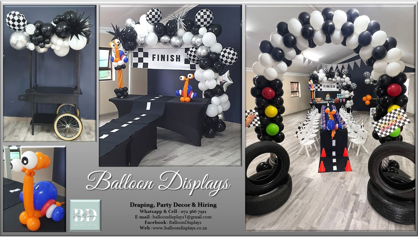 Racing-themed balloon arch with colorful decorations.