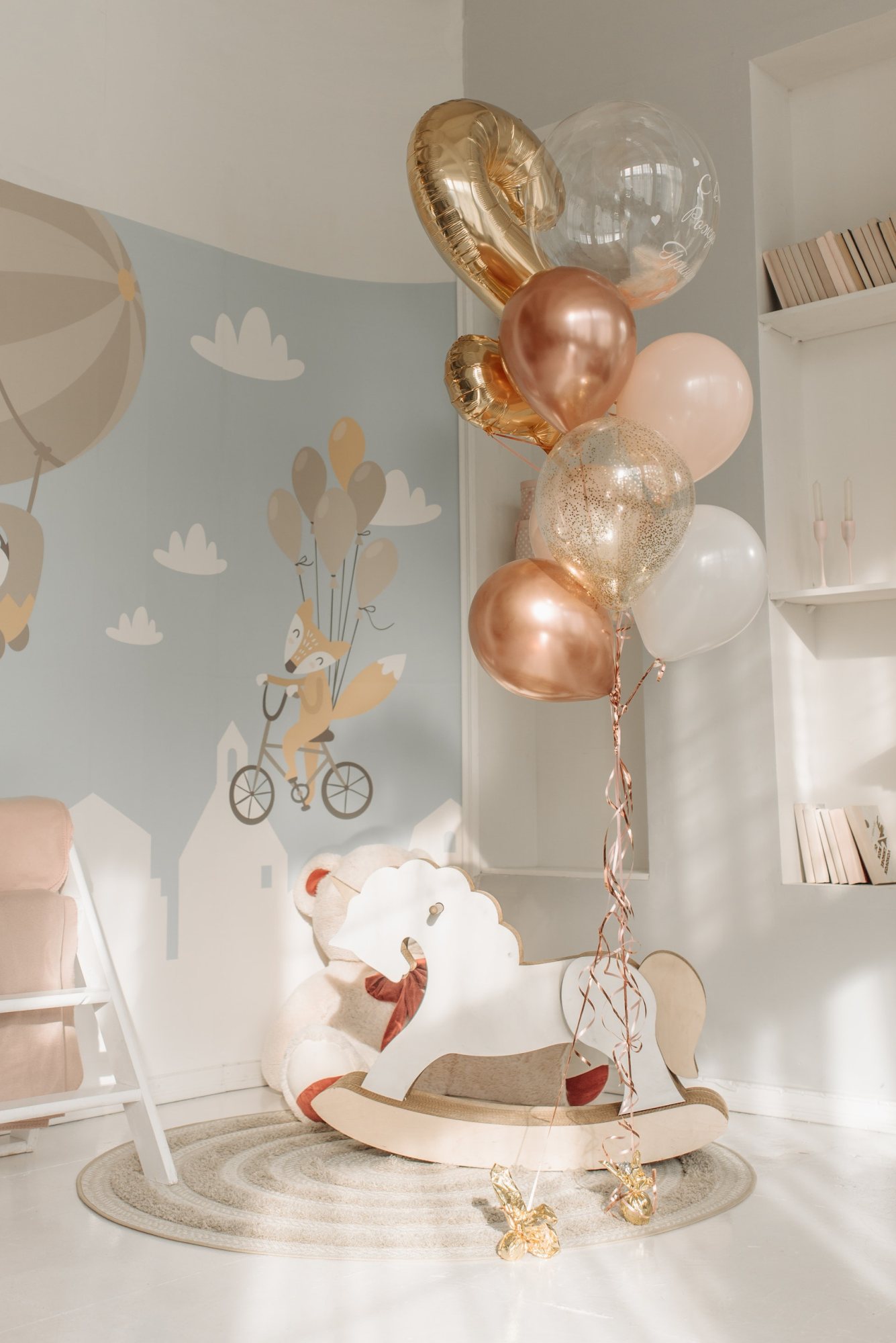 Colorful organic balloon arrangement with a rocking horse in a children's room