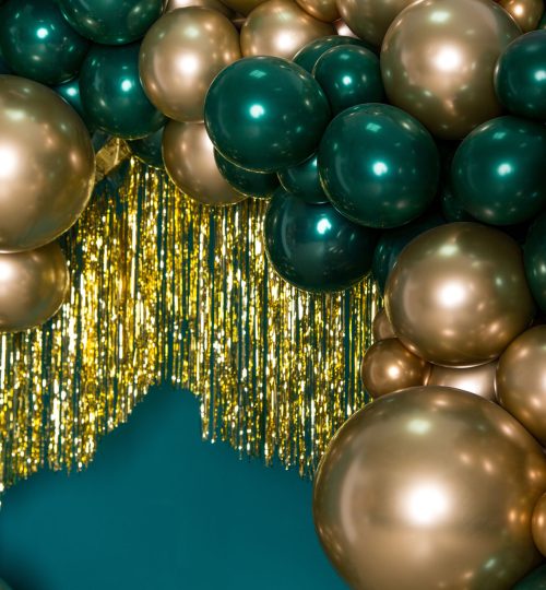 Colorful organic balloon installation with gold and teal balloons