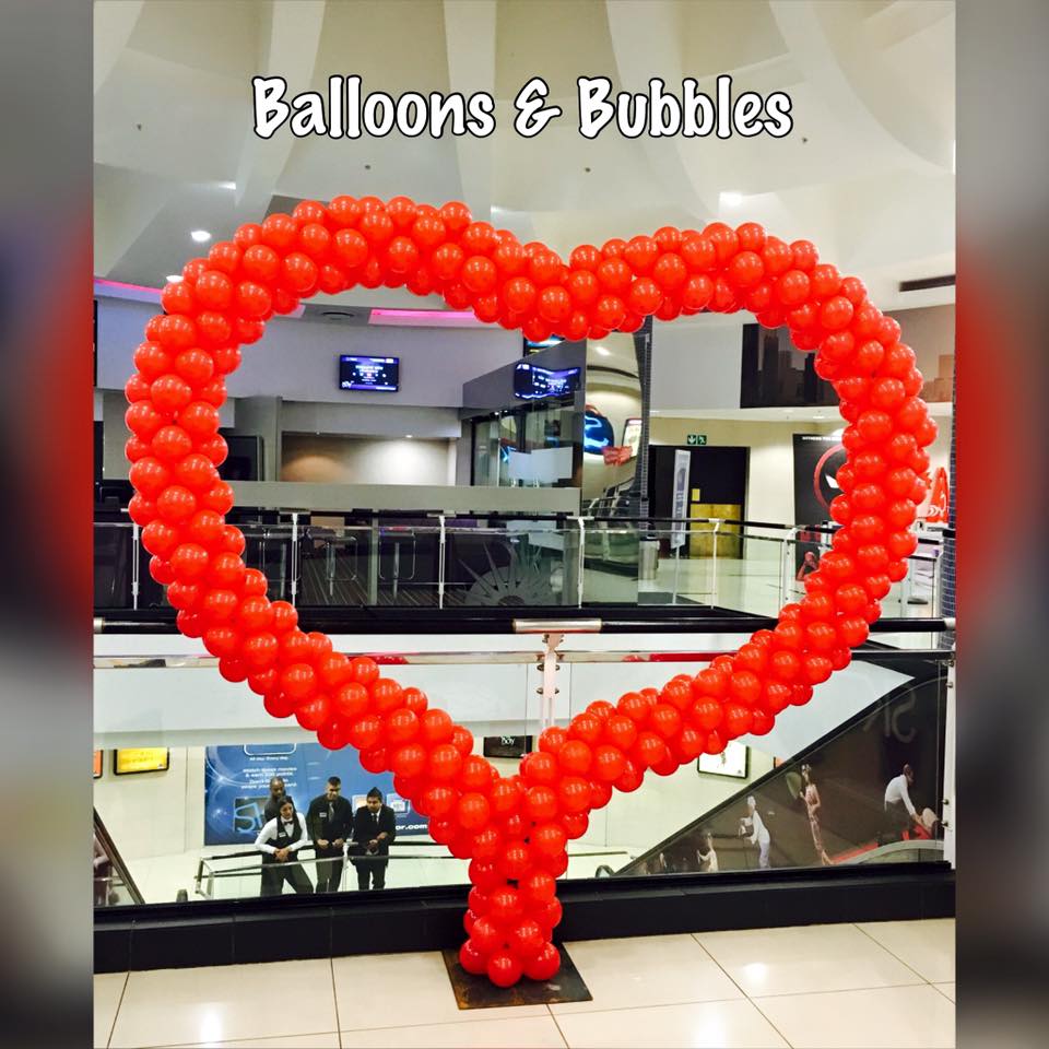 Red heart-shaped balloon arch by Balloons and Bubbles
