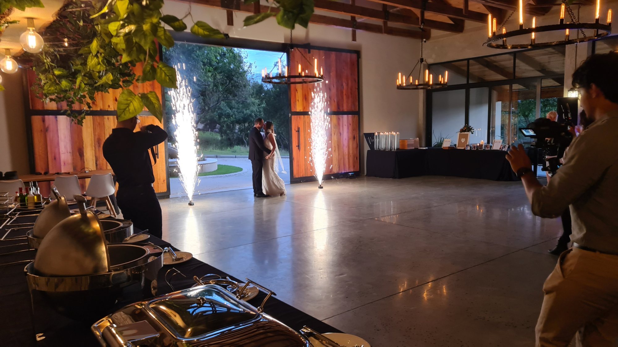Couple dancing with sparklers in a decorated venue.