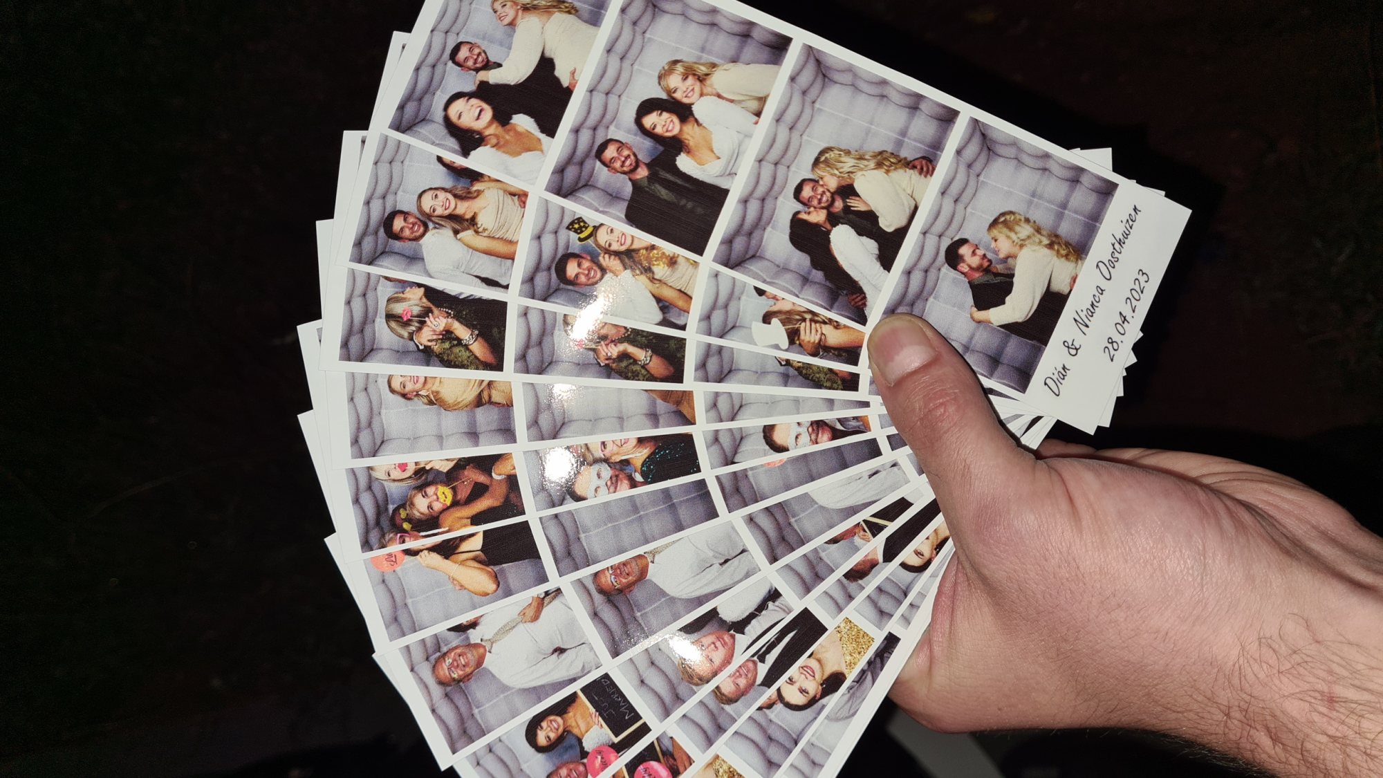 Hand holding multiple photo booth printouts