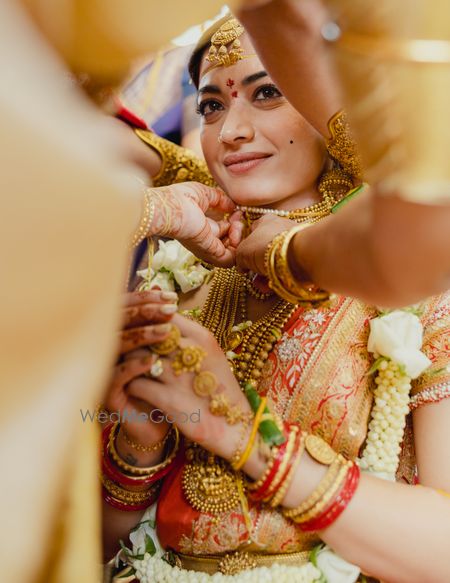 Bridal attire with jewelry and floral garland during a wedding ceremony.