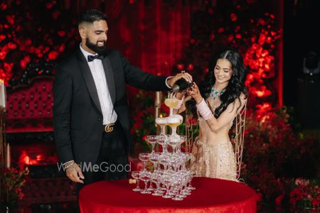 Couple pouring champagne into a glass tower at a wedding.