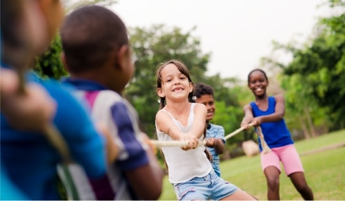 Children playing tug of war in a park