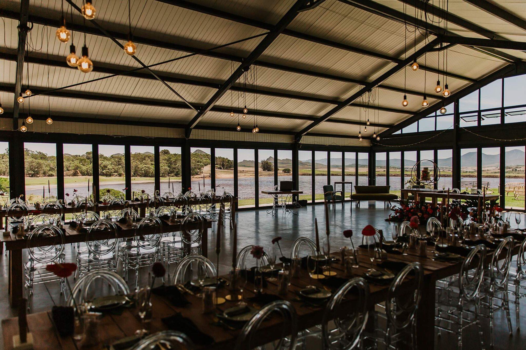 Elegant wedding reception setup with wooden tables and scenic views.