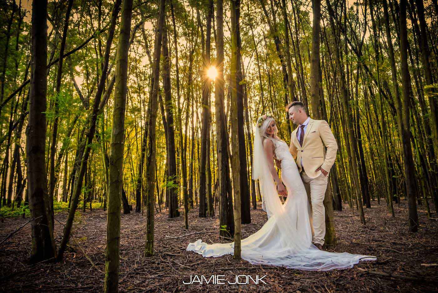 Bride and groom posing in a wooded area