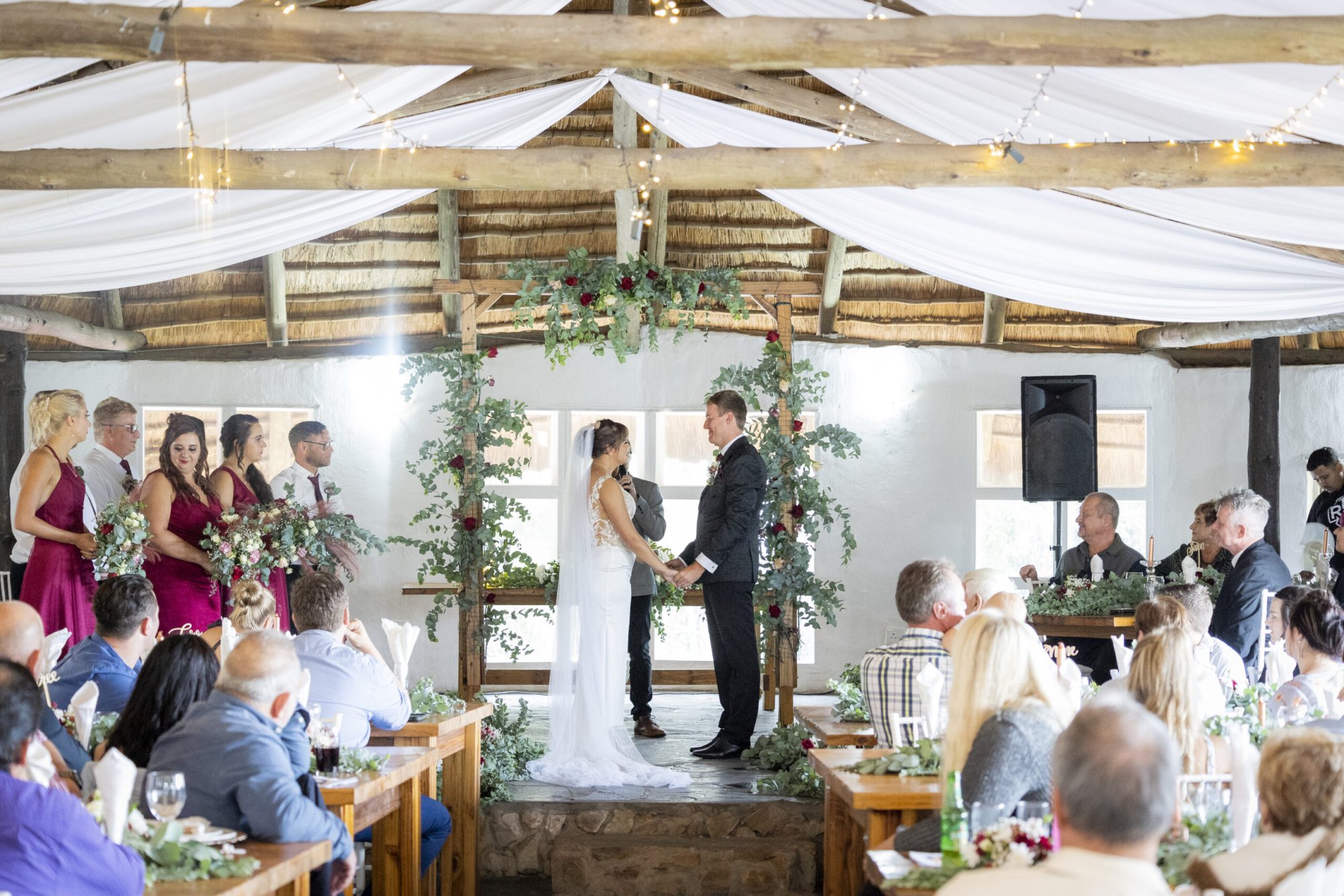 Couple at altar with floral decor in rustic venue