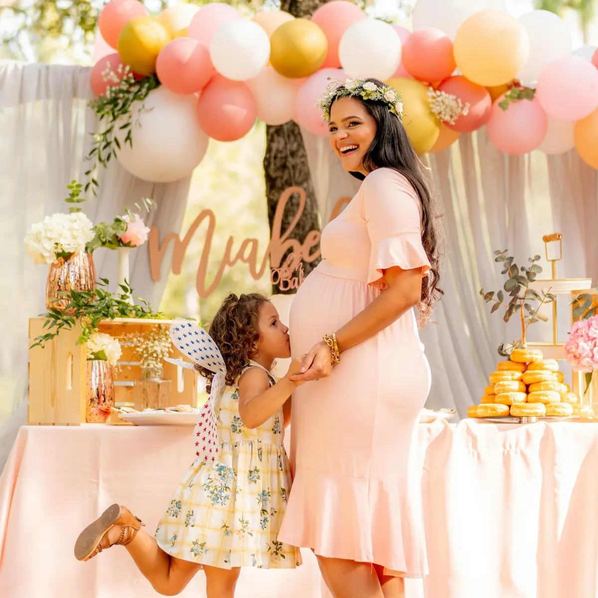 Baby shower décor with balloons, treats, and a mother-to-be