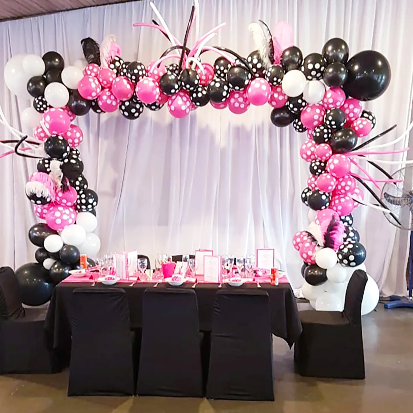 Colorful balloon arch with black, pink, and white balloons