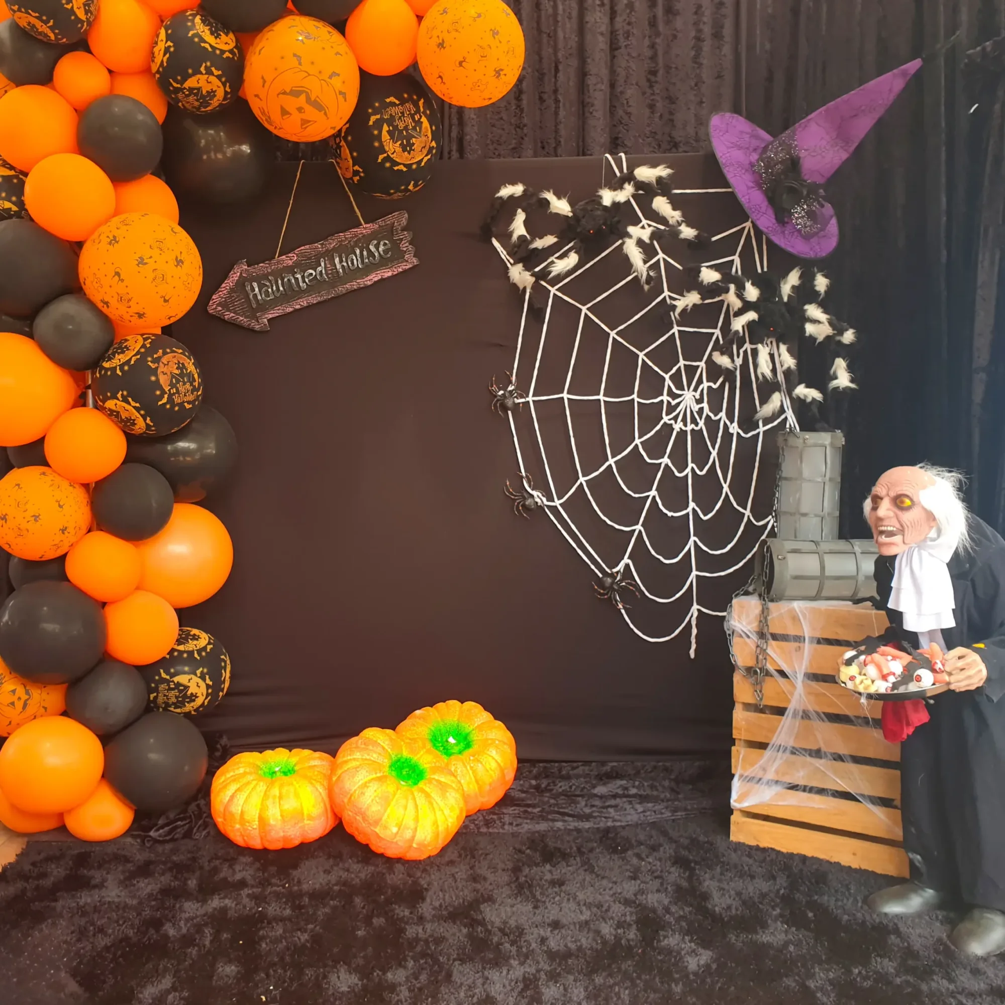 Halloween party setup with décor, pumpkins, and spider web