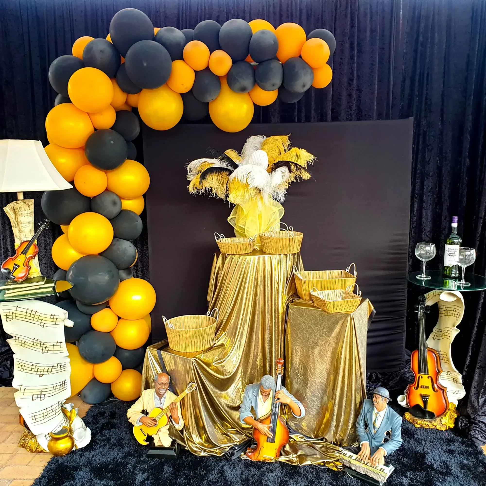 Themed party setup with black and gold balloons and decorative elements