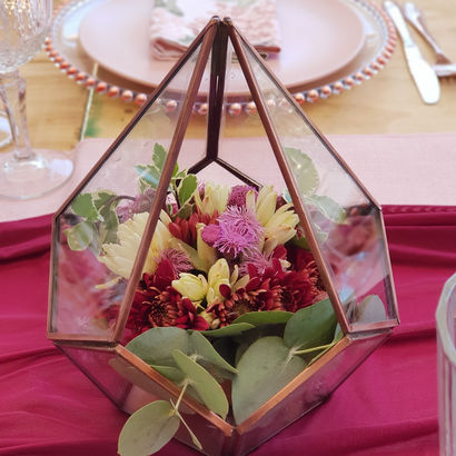 Floral arrangement inside a glass terrarium on a table