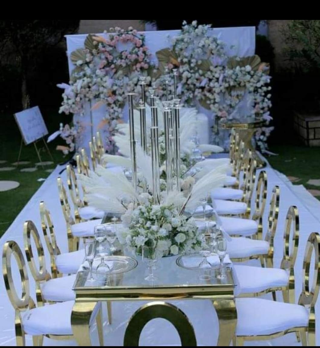 Long dining table set with gold accents and floral decor