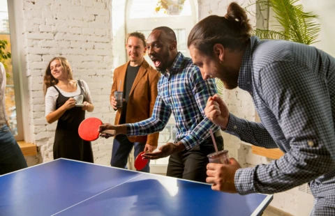 Group playing table tennis in a lively setting