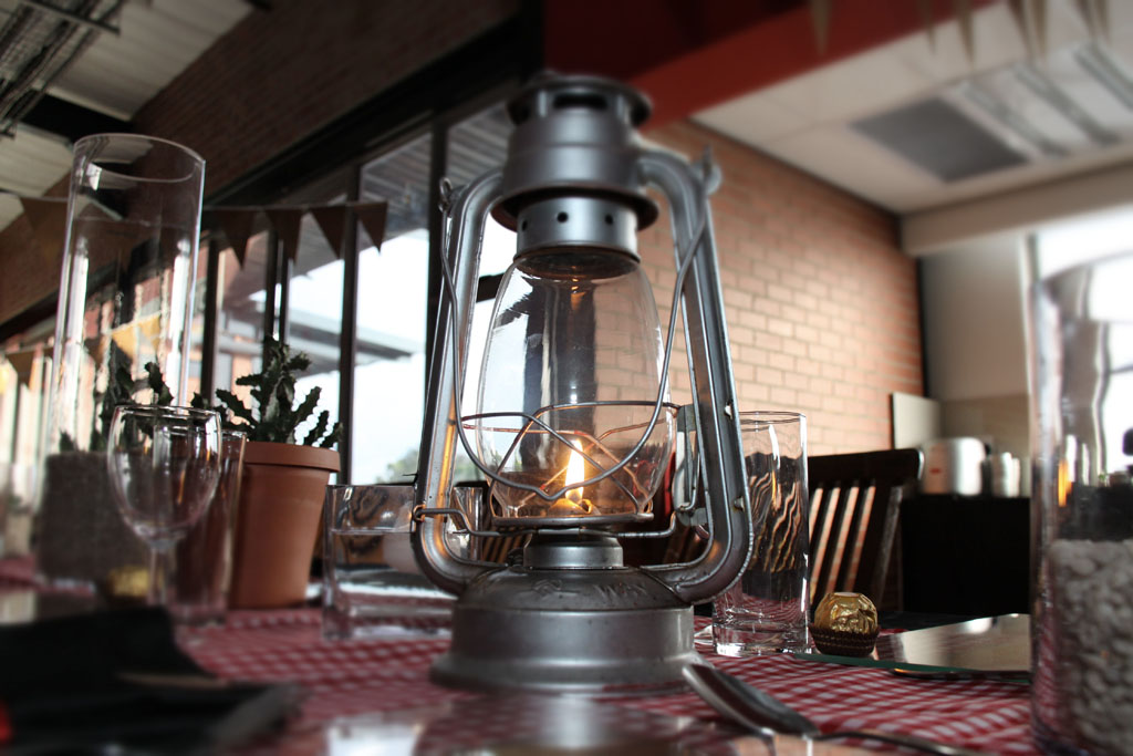 Rustic table with a vintage lantern and glassware